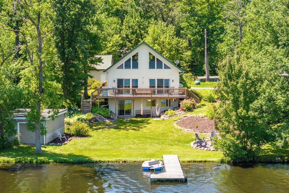 Blake Lake Escape is a charming lakefront home with large windows, wrap-around deck, and a flat yard, a private dock with kayaking, paddle boating, and a custom fire pit. Perfect for relaxing.