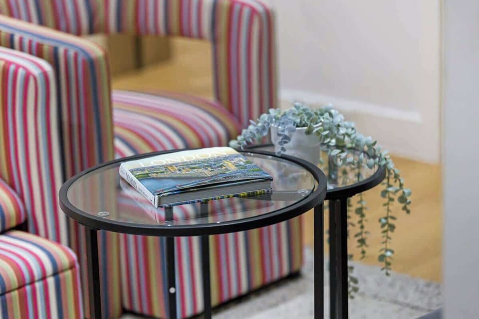- Living room detail with coffee table and greenery  
- Modern décor paired with striped chairs and books  
- Perfect stylish touch for a warm welcoming vibe  