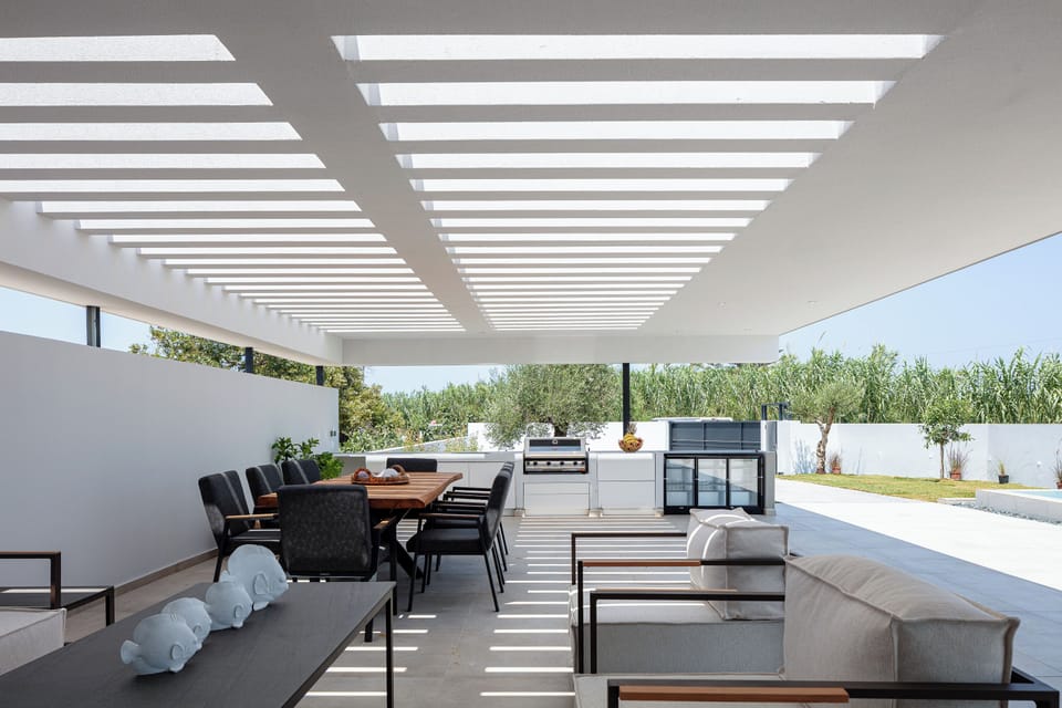 The outdoor space boasts a gas BBQ grill, complete with a mini fridge, ample counter space, and storage cabinets.