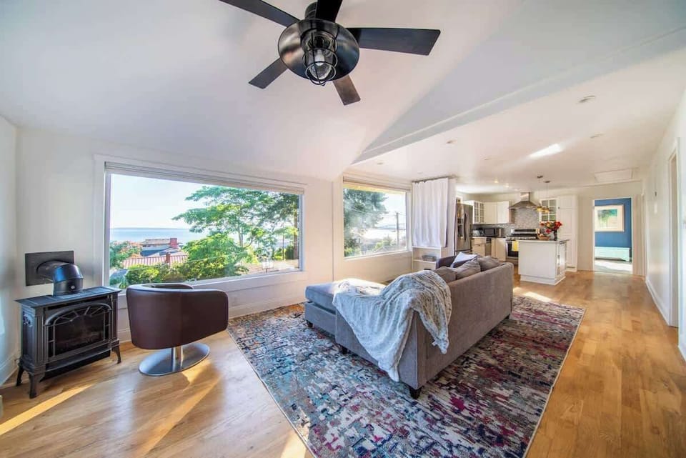 Bright open living area with large windows, cozy seating, and beautiful views that fill the space with natural light.