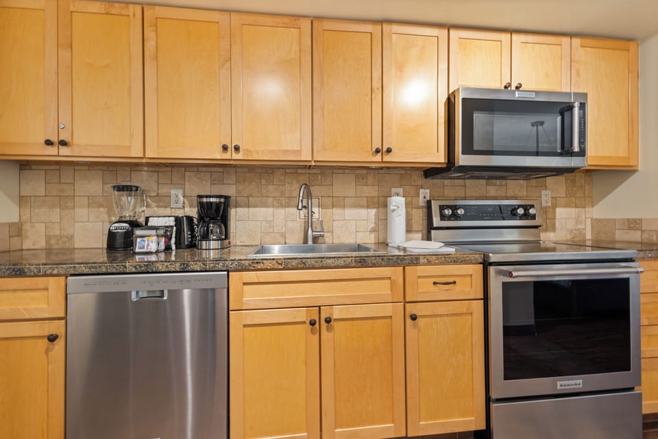 Your fully-equipped kitchen features modern stainless appliances, granite counters, and ample cabinet space—perfect for preparing your favorite meals during your stay.