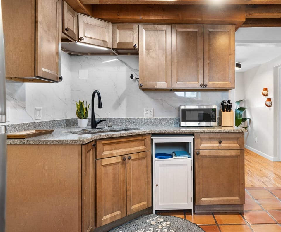 Modern kitchen with wooden cabinets and granite countertops.