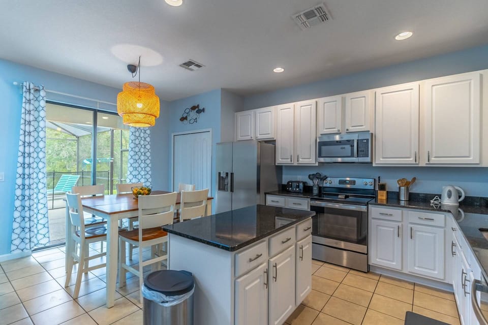 Large kitchen with high top seating and access to the private patio and pool!