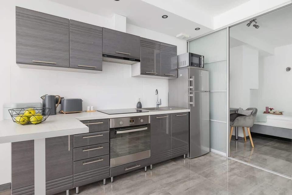 Sleek kitchen with grey cabinets, under-cabinet lighting, and modern appliances.