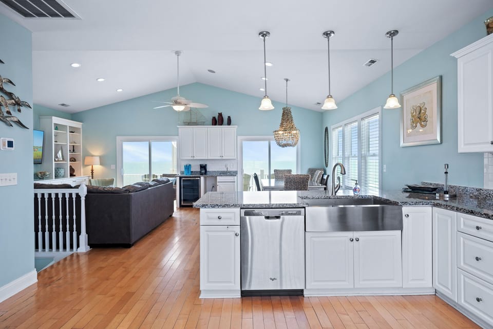Step into this bright, open-concept retreat where soft blue tones and gleaming hardwood set a serene tone. You'll love the sparkling granite island, sleek appliances, and the inviting living space that flows to stunning views beyond.