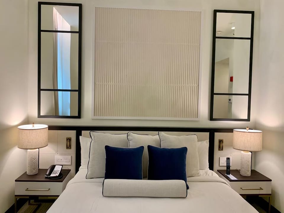 Drift off under warm bedside lighting and luxe layered pillows.