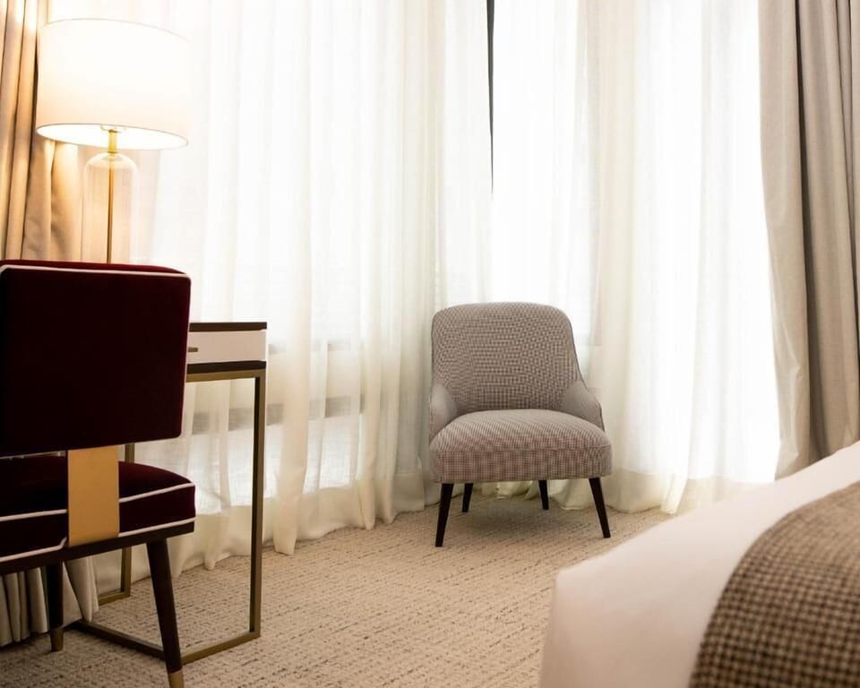 Sip coffee by the sheer-draped window in cozy calm.