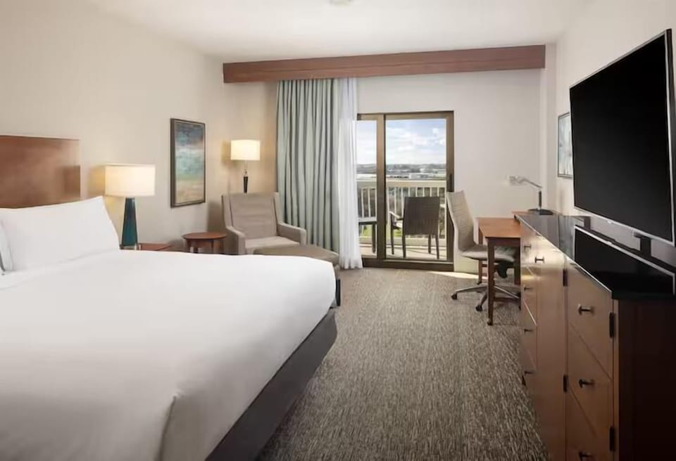 Step into sunlit comfort with balcony doors and relaxing space.