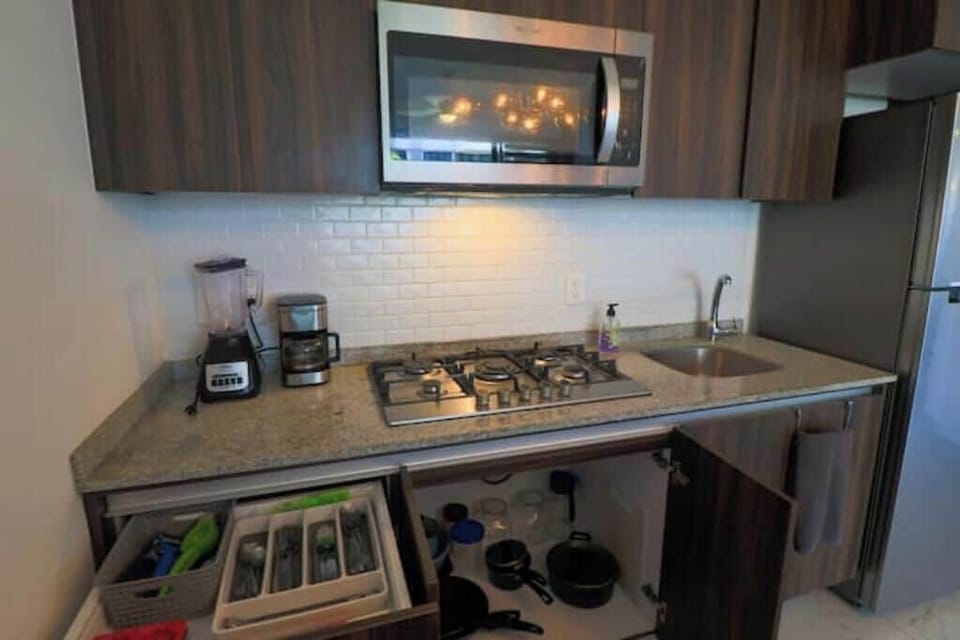 Kitchen with backsplash, blender, coffee maker, 5 burner stove, cooking utensils