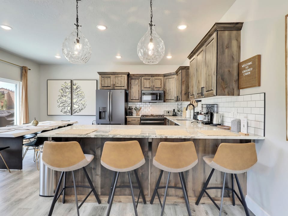 View of Kitchen with Upgraded Appliances and Lighting Pendants, and Counter Seating for 4