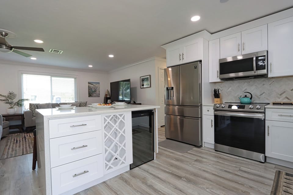This modern kitchen island with a waterfall countertop offers ample space for cooking, gathering, or enjoying quick bites in style
