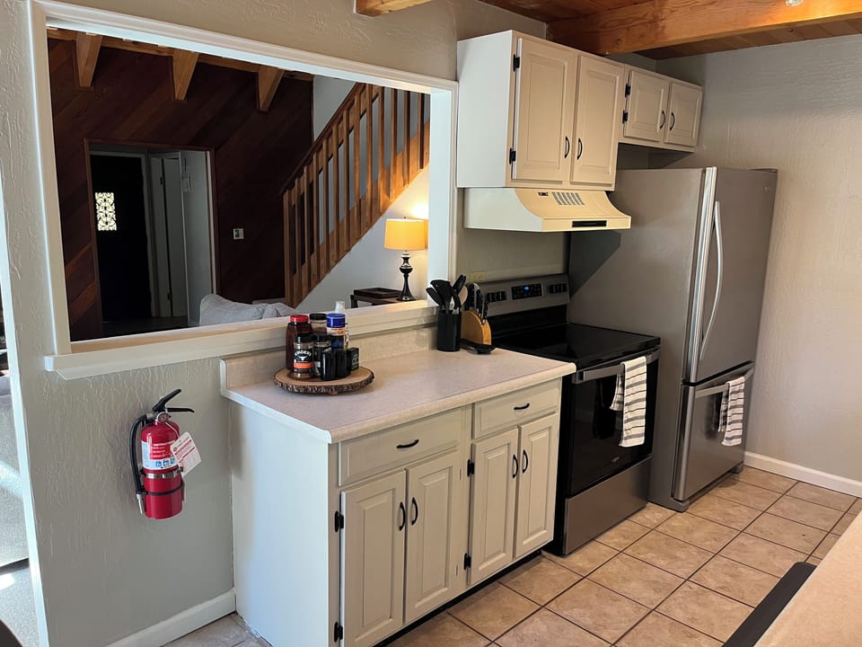 Kitchen with cookware, range, oven, fridge, and cooking essentials