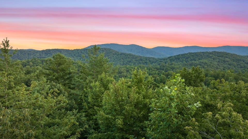 Marvel at stunning mountain and tree views as the sun sets, right from the comfort of our cozy cabin!
