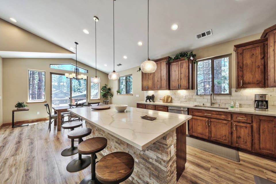 Your gourmet kitchen features rich wood cabinets, quartz counters, and a spacious island where you'll love preparing meals while enjoying forest views.