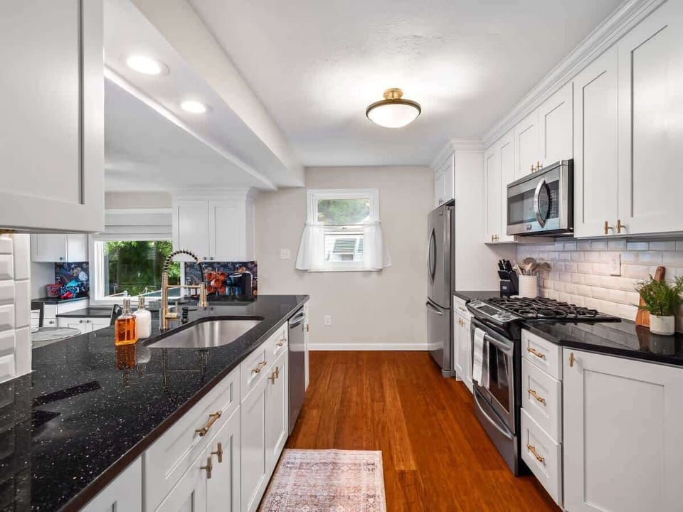 Sleek kitchen w/ dark island, bar seating & plenty of prep space