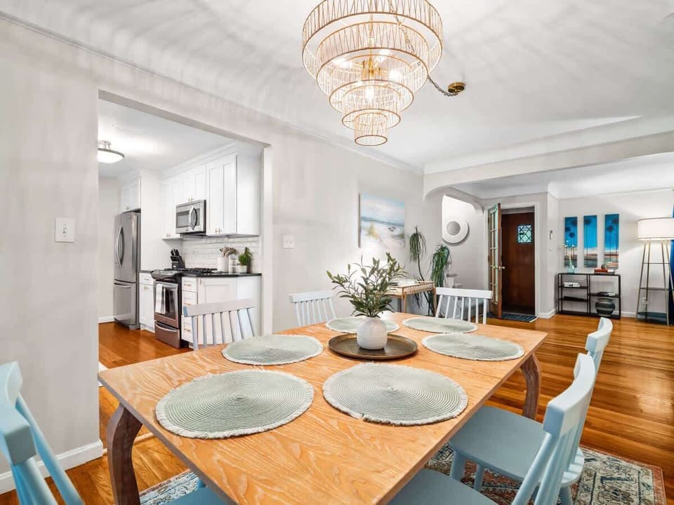 Open dining area w/ round table, soft tones & bright, airy layout