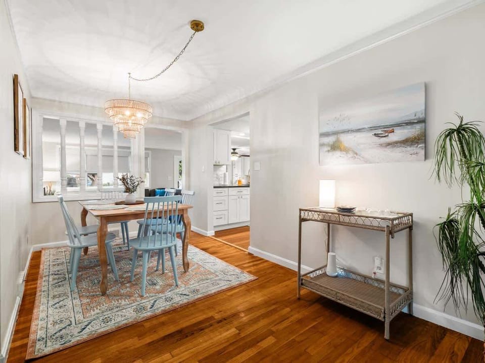 Light-filled dining area w/ glass table & open flow into the living space