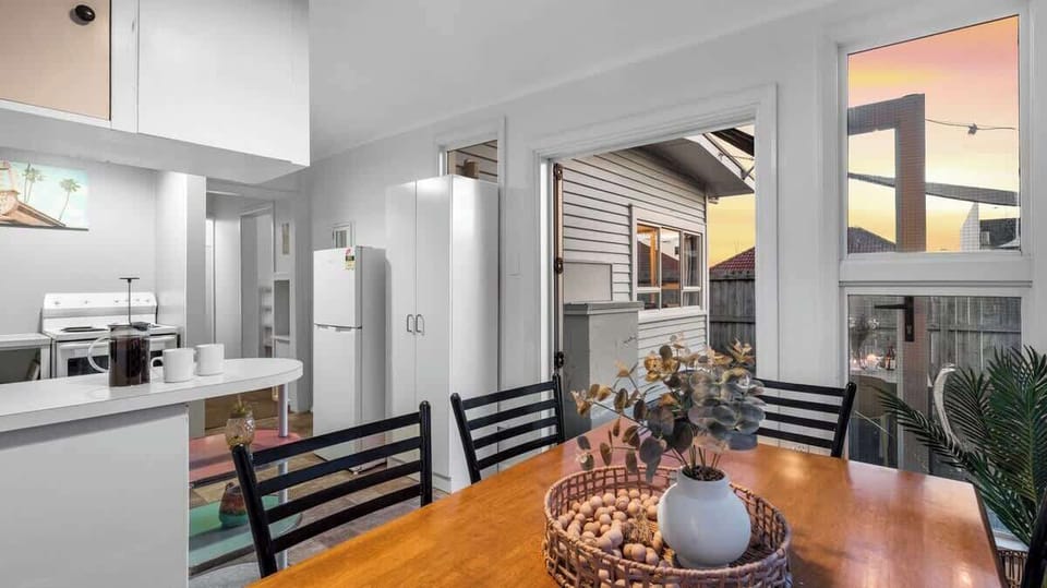 Open plan kitchen dining with doors opening on to outdoor dining area