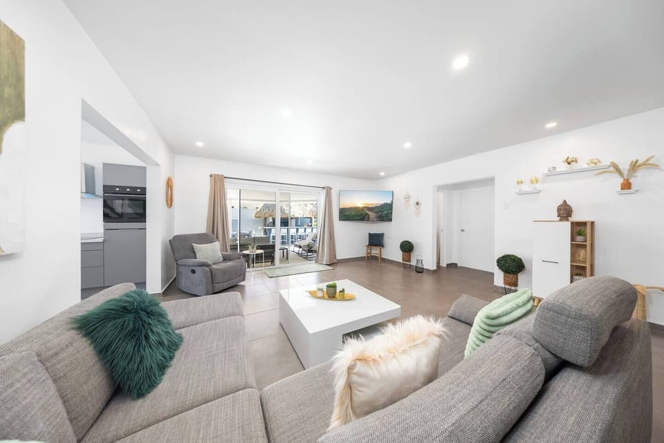 Unwind in our cozy living room: Featuring comfy sofas, a recliner, a TV, and a stylish coffee table for your relaxation.