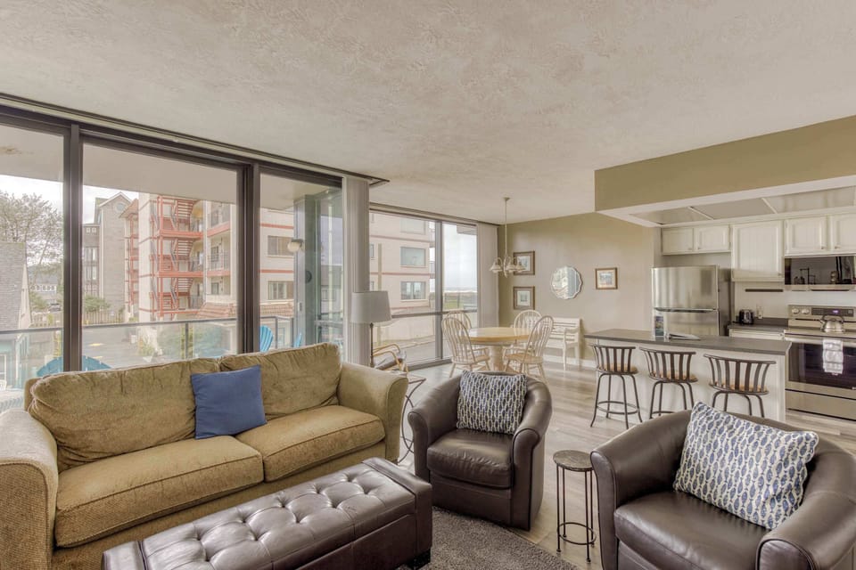Modern open-concept living space with large windows, cozy seating, spacious dining area, and a bright, inviting atmosphere for comfortable family living.