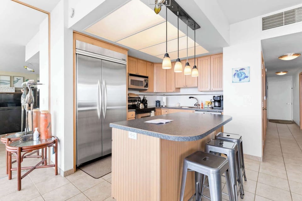 Cook and socialize with ease! This open-concept kitchen features a large island with seating, a full-size refrigerator, and all the essentials for your vacation meals.