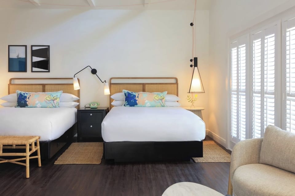 Relax together in airy beds framed by chic modern lighting.