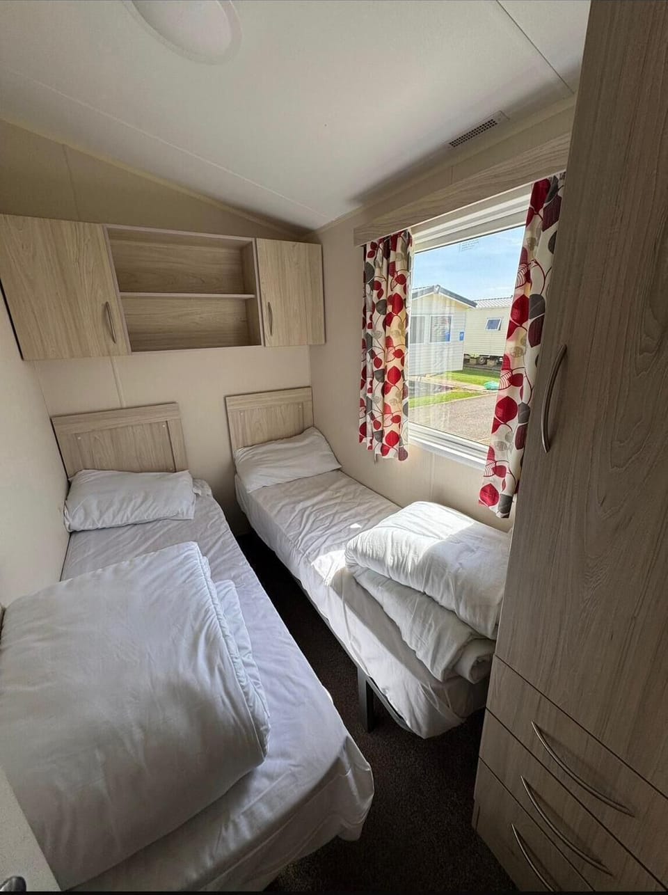 Practical twin caravan bedroom, designed to offer comfort and functionality for your UK travels!