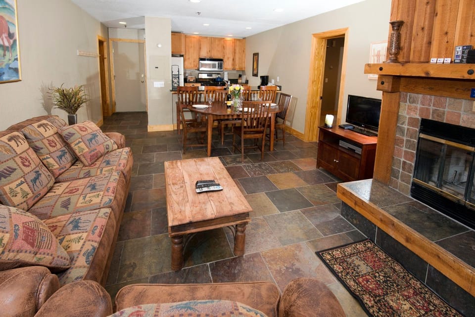 Gather in the inviting living area with comfortable seating and a warm wood-burning fireplace.