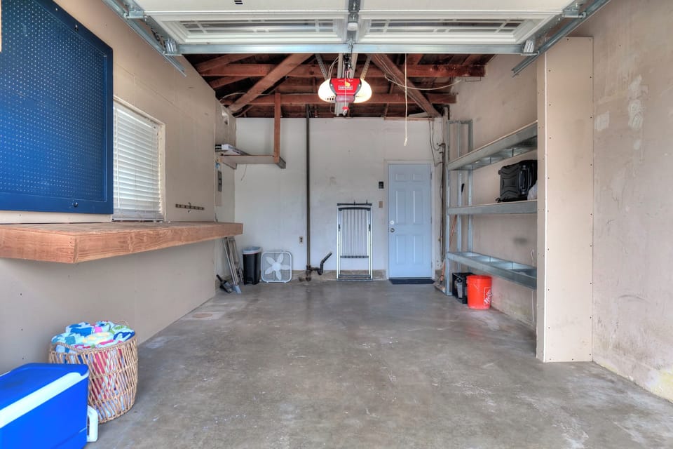Spacious garage with ample storage and a workbench, perfect for beach gear and more.