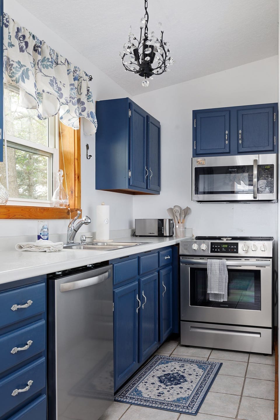 Charming kitchen w/ blue cabinets, white countertops & plenty of space to cook & gather.