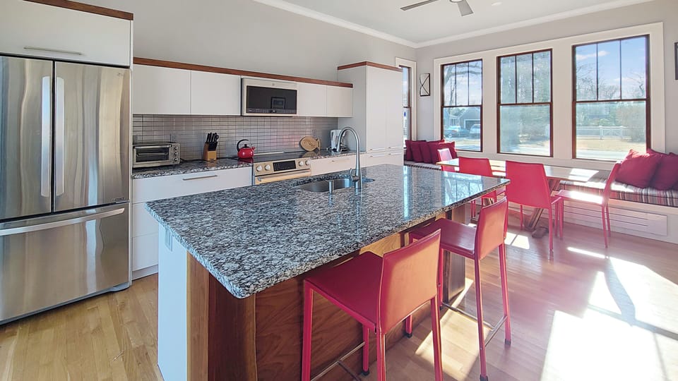 Kitchen has stainless appliances and a large center island with counter seating