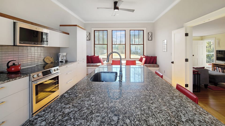 Kitchen has stainless appliances and a large center island with counter seating
