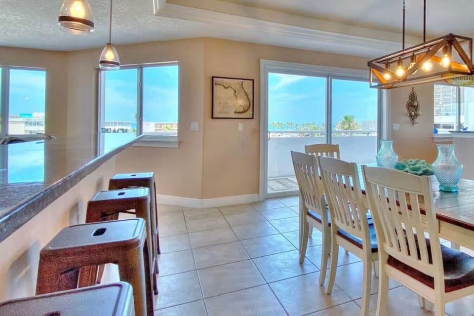 Bright dining space w/ large windows, creating a cheerful setting for shared meals.