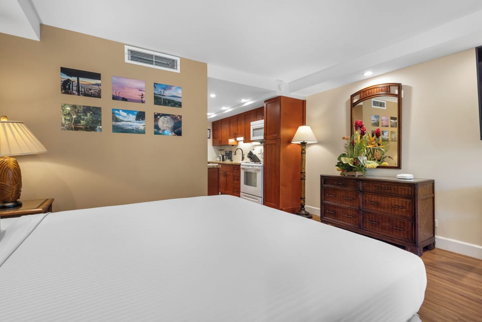Unwind in this inviting studio where a plush bed awaits, complemented by warm tropical touches and a convenient kitchenette for your home-away-from-home comfort.