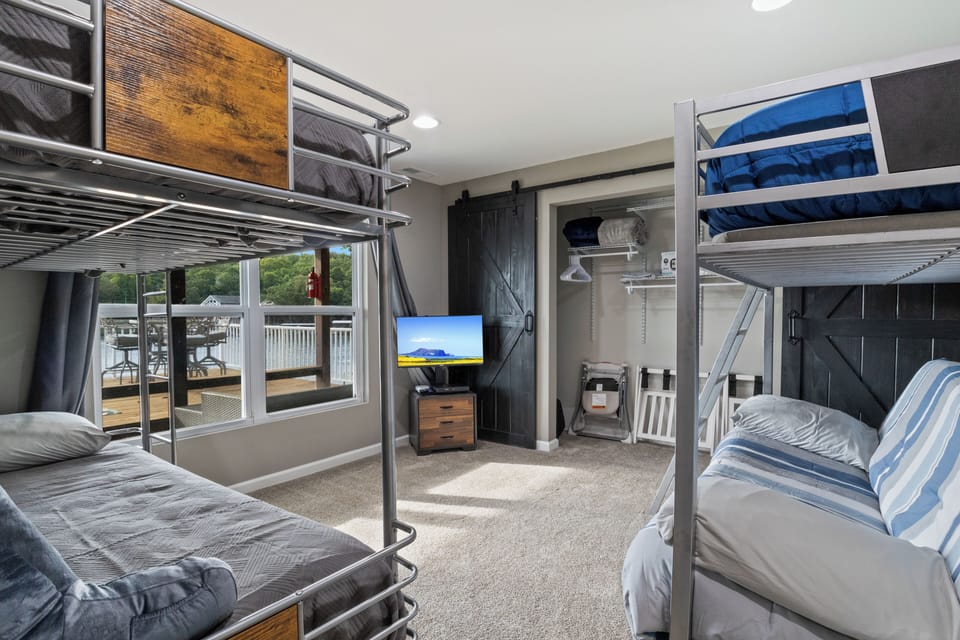 Open closet with sliding barn doors, stocked with folding chairs and baby essentials for added convenience.