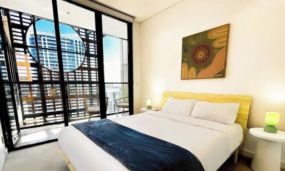 A cozy bedroom featuring a comfortable bed and vibrant wall art.
