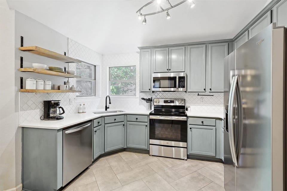 Beautiful and spacious kitchen equipped with a coffee maker, stove, oven, microwave, and refrigerator, to make your meals easier