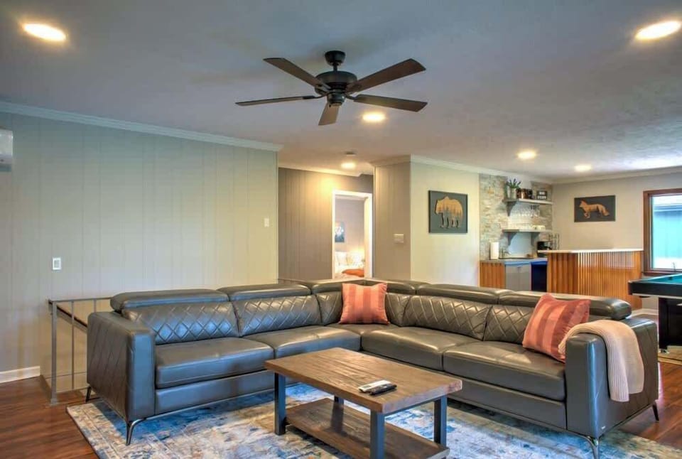 The dedicated recreational room features a large wrap-around sofa, ideal for lounging, entertainment, or enjoying quality time with loved ones.