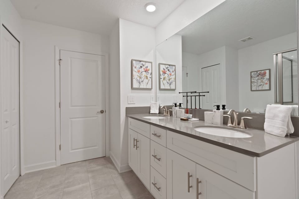 This bright bathroom offers a stylish double vanity with plenty of counter space for your travel essentials. Charming floral art and a clean, neutral palette create a refreshing atmosphere for your stay.