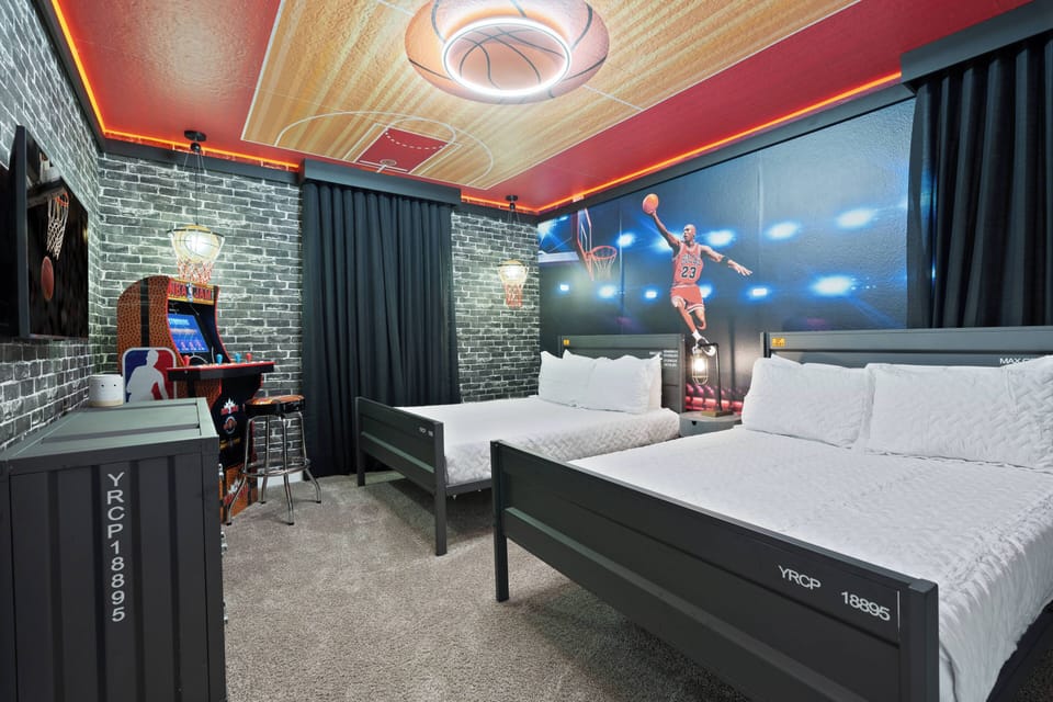 Immerse yourself in the vibrant energy of this themed room, highlighted by a striking basketball player mural. The sleek dark furnishings and textured stone wall create a stylish vibe, while warm LED lighting adds a playful touch.