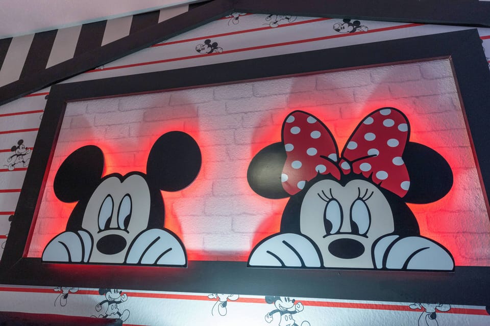 This charming space features a whimsical mural of beloved characters, adding fun with vibrant colors and soft lighting. It's a cozy atmosphere ideal for family gatherings and playful relaxation.