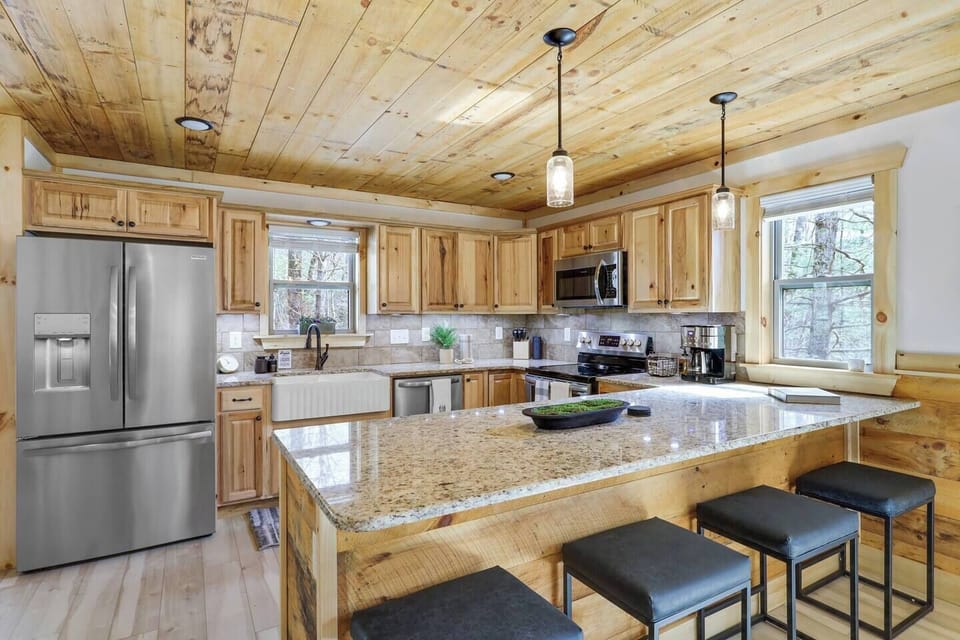 Sleek granite countertops provide ample work space for culinary creations complimented by stainless steel appliances that gleam under the soft pendant lighting.  The rich wooden cabinetry offers plenty of storage!