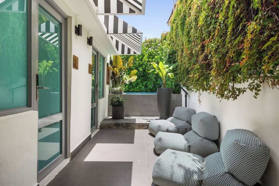 Stylish and comfortable outdoor couch set against a backdrop of exotic plants, creating an urban oasis.