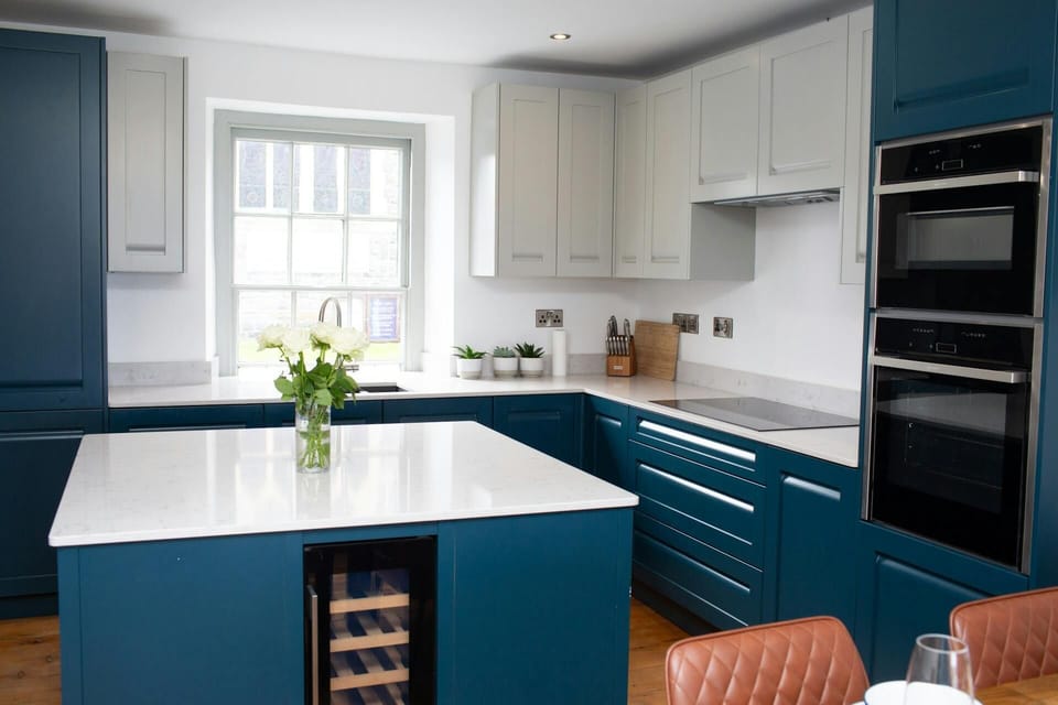Kitchen island with wine fridge. Electric double oven and hob