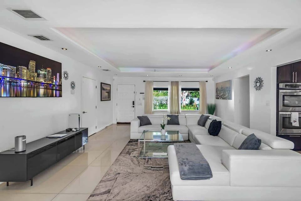 Contemporary living room with cityscape vibes—perfect for vacation rentals and short-term stays. Enjoy sleek design, cozy seating, and ambient lighting ideal for relaxing, entertaining, or remote work.
