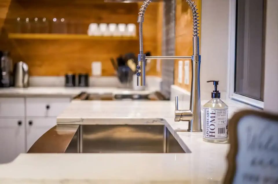 Granite countertops, large stainless steel sink, and tall faucet