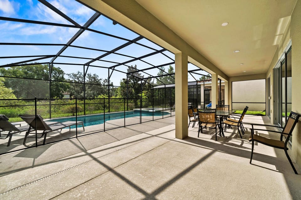 - Spacious lanai with lounge chairs and shaded dining area setup  
- Screened pool view makes outdoor meals enjoyable year-round  
- Family-friendly Orlando rental with outdoor living space