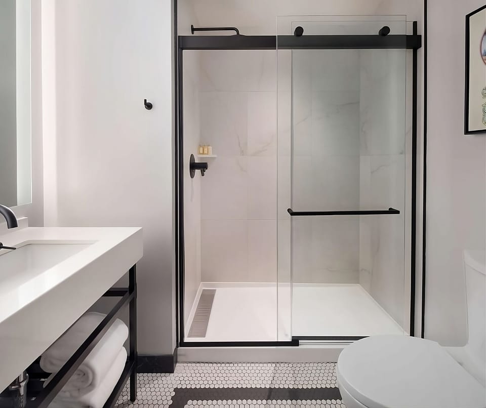 Refresh under a sleek glass shower in a spotless bath.