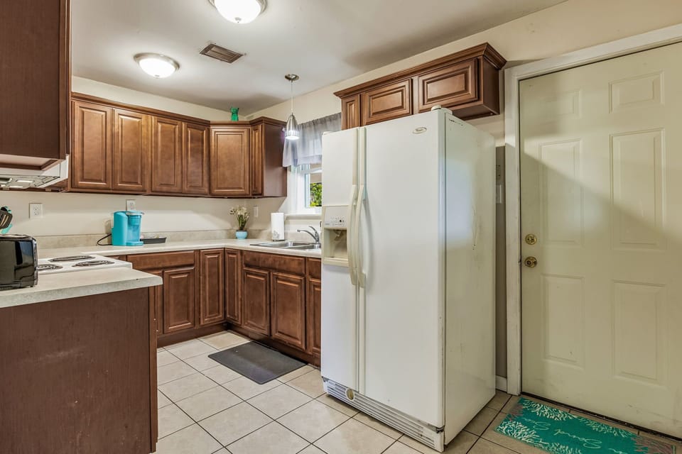 The kitchen features appliances such as refrigerator, sink, and stovetop.