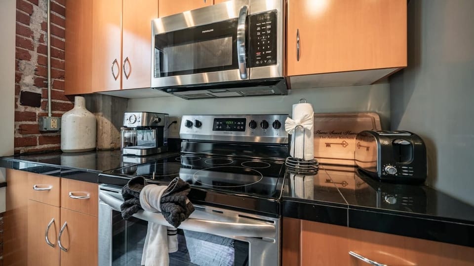 Modern kitchen with stainless steel appliances, sleek countertops, and industrial-style accents, perfect for preparing meals in style.